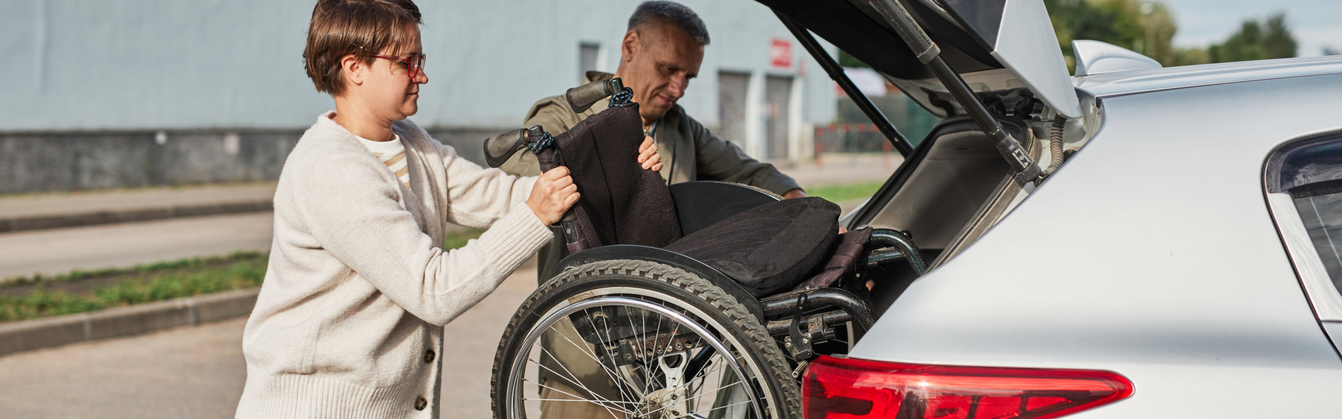 two people put the wheelchair to the car