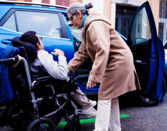 woman assist the man in a wheelchair