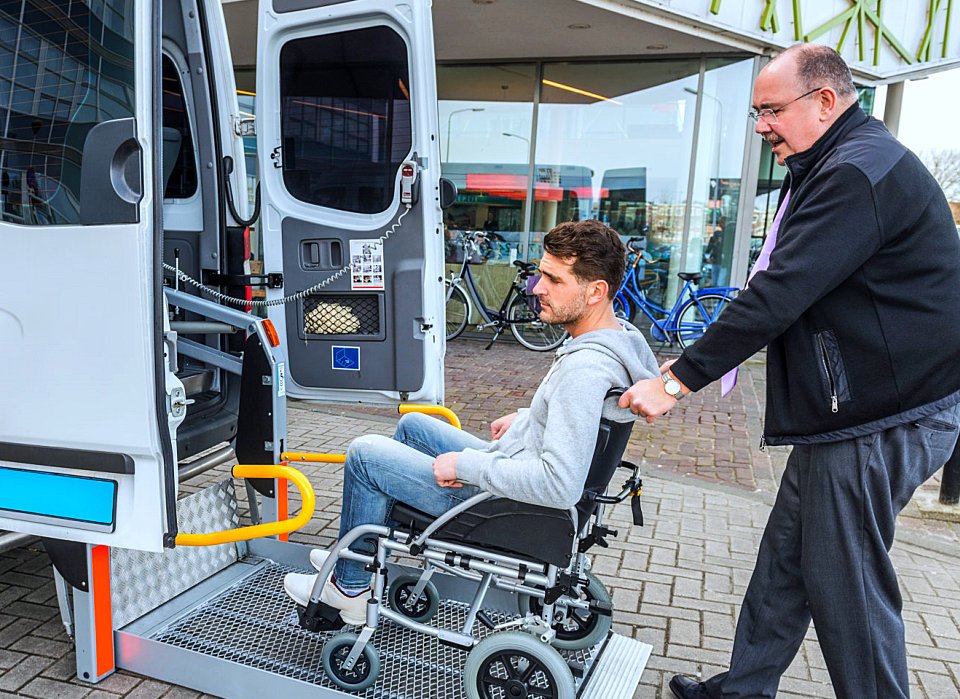 disabled man with his wheelchair pushing by an old man